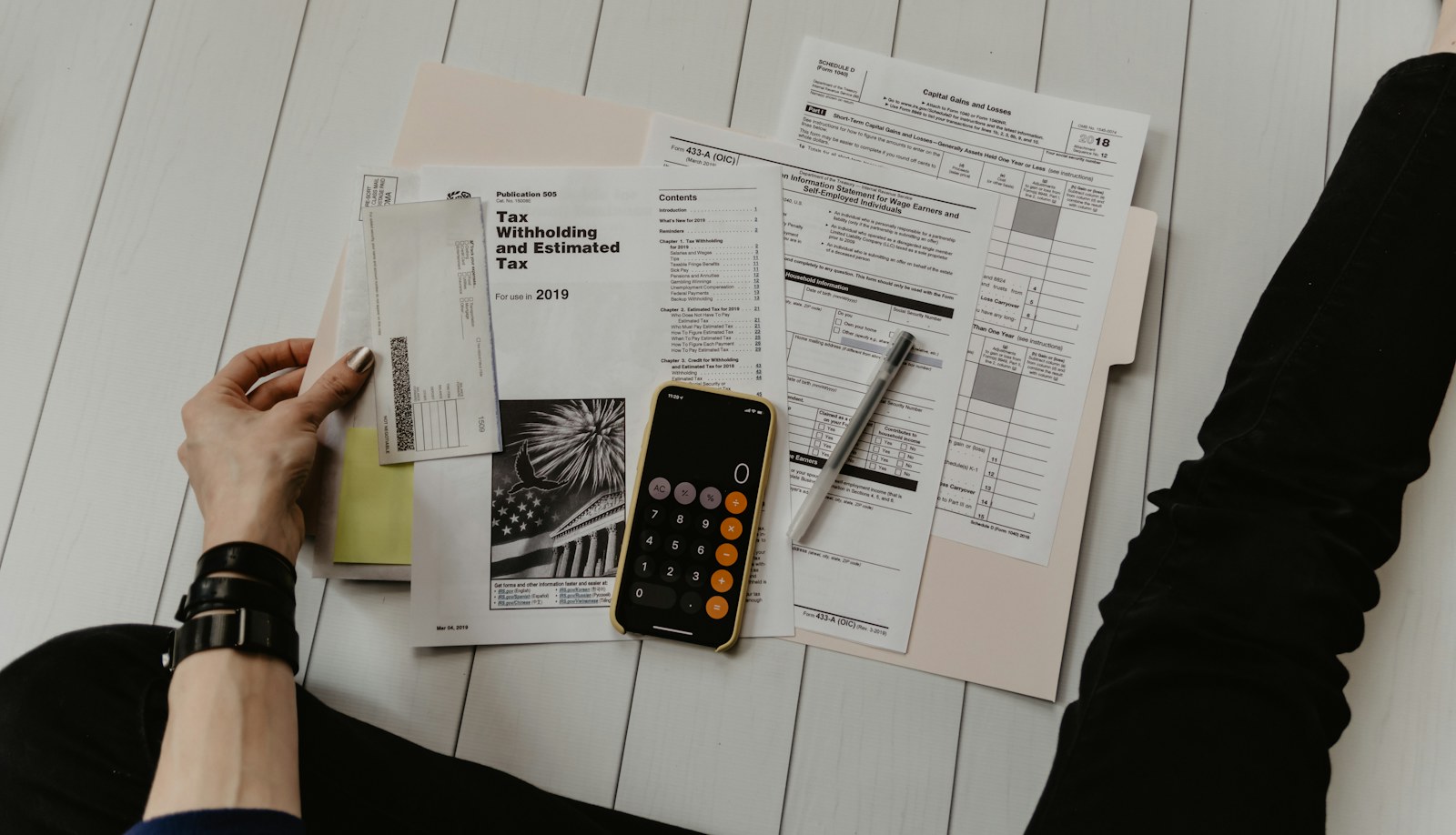 Financial planning documents, a calculator and a smartphone on a desk